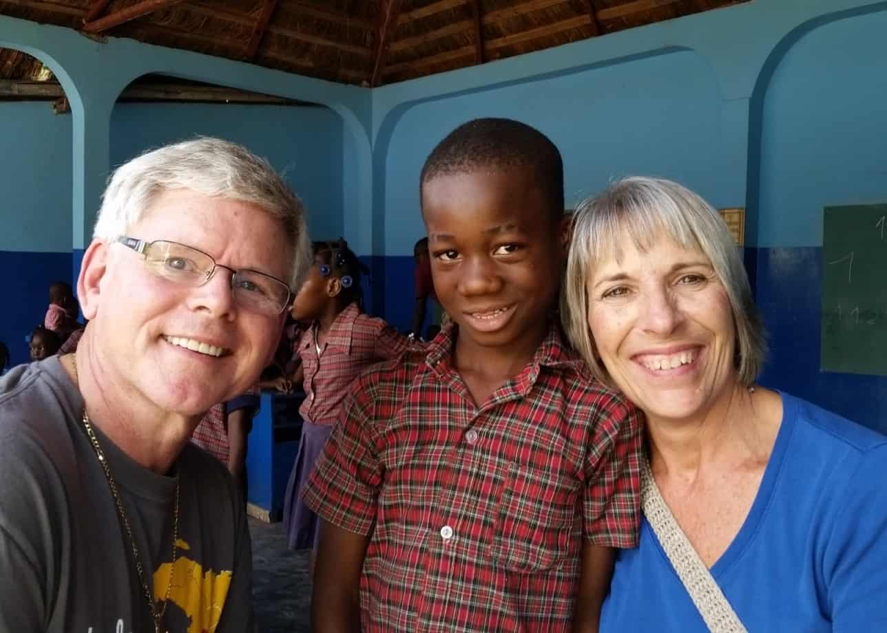 Photo of Doug and Lois Fearing in Haiti with a school aged child.