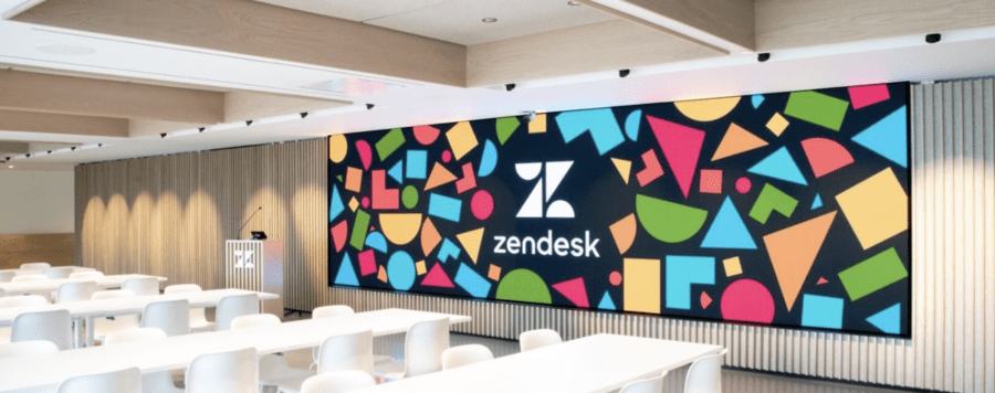 A large video wall display with the Zendesk logo at the center.