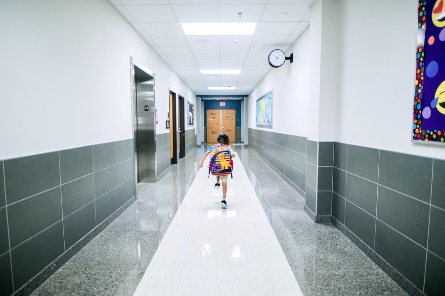 Little girl alone in a school hallway.